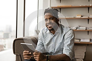 Portrait of smiling young african man holding digital tablet.