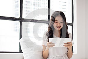 Portrait of a smiling young asian beautiful girls are shopping online with credit card in the living room