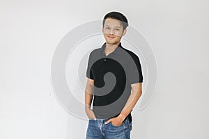 Portrait of smiling young asian man wearing black shirt and denim pant isolated on white