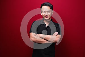 Portrait of smiling young asian man wearing black shirt isolated on red