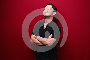 Portrait of smiling young asian man wearing black shirt isolated on red