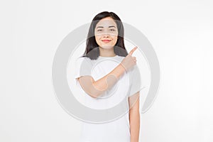 Portrait of smiling young asian woman wearing summer t shirt pointing at copy space by finger isolated on white blank background