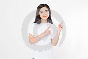 Portrait of smiling young asian woman wearing summer t shirt pointing at copy space by finger isolated on white blank background