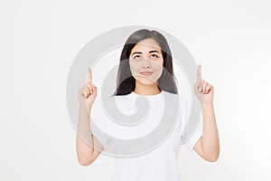 Portrait of smiling young asian woman wearing summer t shirt pointing at copy space by finger isolated on white blank background