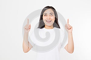 Portrait of smiling young asian woman wearing summer t shirt pointing at copy space by finger isolated on white template and blank