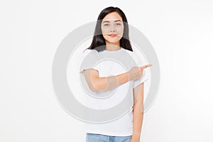 Portrait of smiling young asian woman wearing summer t shirt pointing at copy space by finger isolated on white template and blank