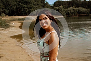 Portrait Of Smiling Young Beautiful Woman In Front Of A Lake