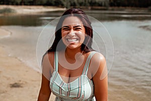 Portrait Of Smiling Young Beautiful Woman In Front Of A Lake
