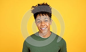 Portrait of smiling young black guy hipster posing on yellow