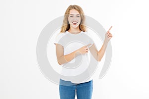 Portrait of smiling young blonde caucasian woman wearing summer t shirt pointing at copy space by finger isolated on white