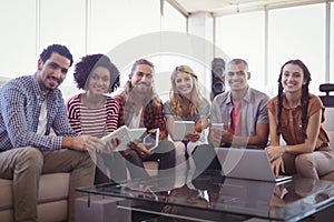 Portrait of smiling young business people sitting on sofa