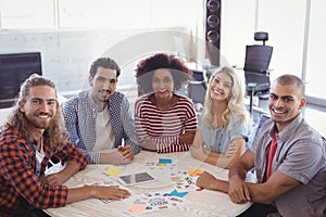 Portrait of smiling young business team sitting together at desk