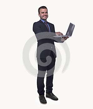 Portrait of smiling young businessman holding an open laptop, full length, studio shot