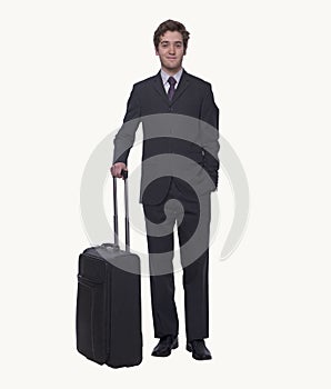 Portrait of smiling young businessman holding a suitcase, studio shot