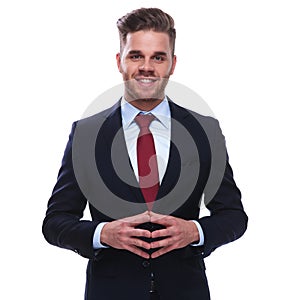 portrait of smiling young businessman standing with fingers together