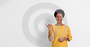 Portrait of smiling young businesswoman pointing at copy space for marketing on white background