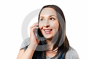 Portrait of a smiling young casual brunette woman talking on mobile phone over white background isolate