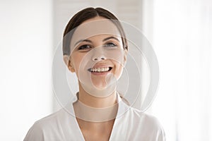 Portrait of smiling young Caucasian woman in bathrobe