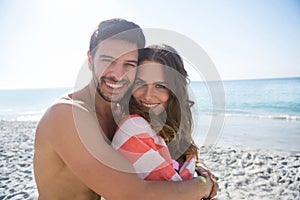 Portrait of smiling young couple embracing at beach