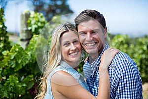 Portrait of smiling young couple hugging at vineyard