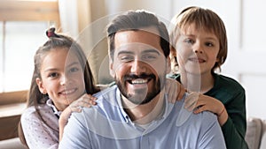 Portrait of smiling young dad posing with two kids