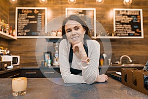 Portrait of smiling young female coffee shop owner, confident woman standing at the counter