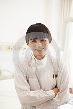 Portrait of smiling young female doctor with arms crossed in a hospital