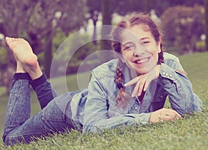 Portrait of smiling young girl while lying in outdoors