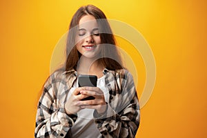 Portrait of a smiling young girl using smartphone