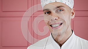 Portrait of a smiling young guy with braces in his mouth in medical uniform.