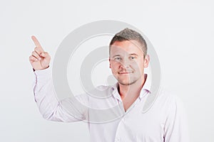 Portrait of smiling young guy pointing upwards