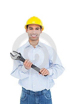 Portrait of a smiling young handyman holding a wrench