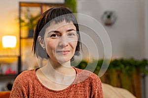 Portrait of smiling young happy Hispanic woman girl with short brown hair looking at camera at home