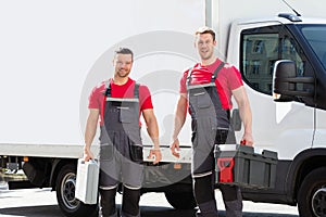 Portrait Of A Smiling Young Male Technicians Holding Tool Box