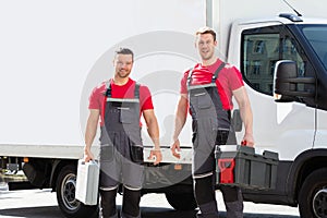 Portrait Of A Smiling Young Male Technicians Holding Tool Box photo