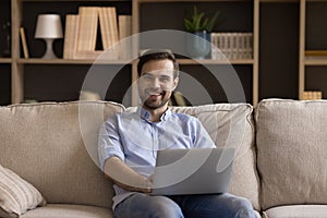 Portrait smiling young man freelancer working on laptop from home