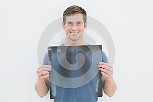 Portrait of a smiling young man holding lung xray