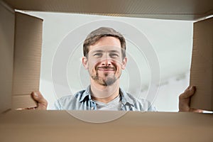 portrait smiling young man looking into box