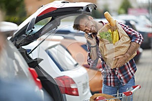 Smiling Young Man Packing Groceries