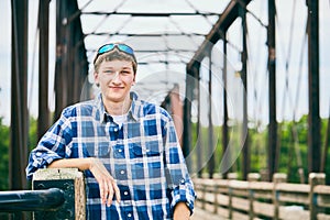 Portrait of smiling young man standing on bridge