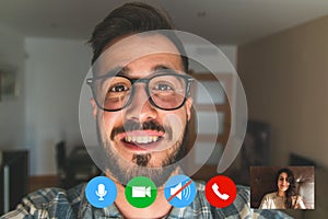 Portrait of a smiling young man talking o video call from home, screen view of the happy young man using a webcam, communicating