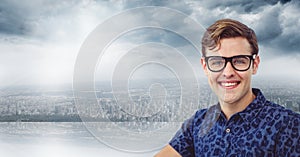 Portrait of smiling young man wearing glasses against cloudy sky