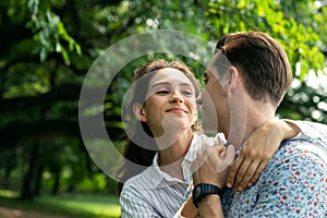 Portrait smiling young man and woman couple in love hugging in the park at summer season with warm sunlight. people and lifestyle