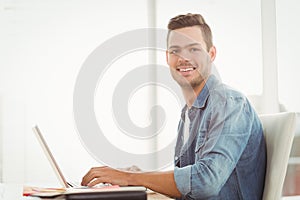 Portrait of smiling young man working on laptop