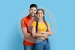 Portrait Of Smiling Young Middle Eastern Couple Embracing And Looking At Camera
