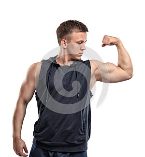 Portrait of smiling young muscular guy shows arm muscles - biceps.