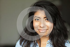 Retrato joven espanol una mujer. ella es un feliz sobre el gris 