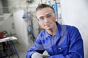 Portrait of smiling young trainee in plumbery photo
