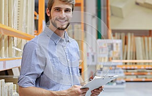 Portrait of a smiling young warehouse worker working in a cash and carry wholesale store