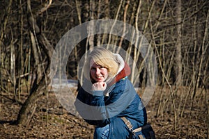 Portrait of a smiling young woman at the edge of the forest in early spring